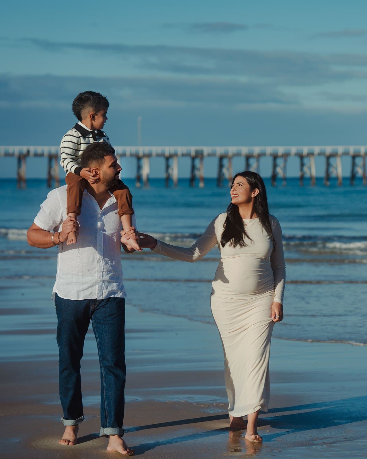 Familia joven feliz en la playa